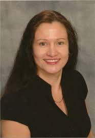 Head shot of woman with dark hair and neutral background